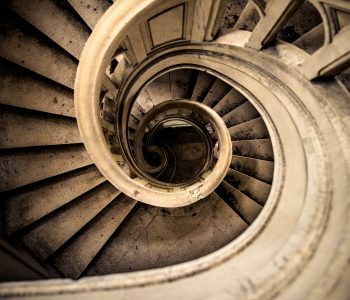 photo d'urbex d'un magnifique escalier en pierre en colimaçon vu de dessus