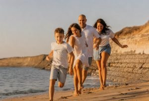 Famille courant sur la plage pendant une séance photo à Soulac-sur-Mer au coucher du soleil